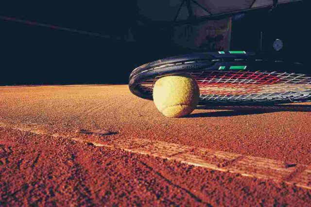 racchetta e pallina da tennis a terra