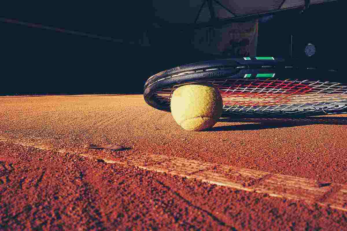 racchetta e pallina da tennis a terra