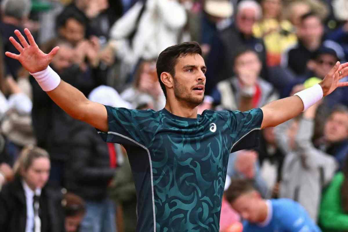 Lorenzo Musetti allarga le braccia durante un match