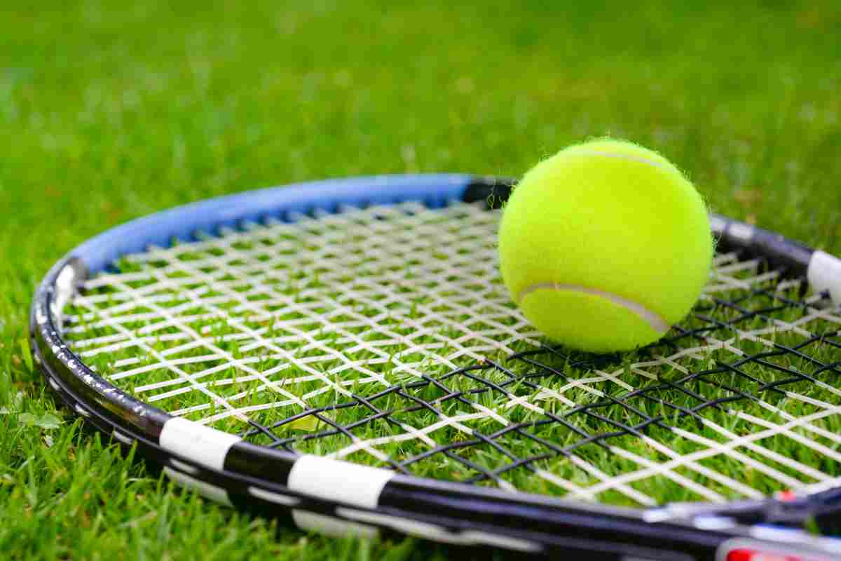 Racchetta e pallina da tennis sull'erba